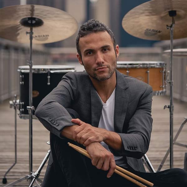 Juan Felipe in front of drums on pier