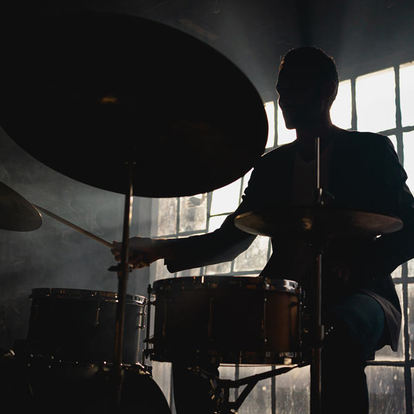 Juan Felipe playing drums in smoke-filled loft